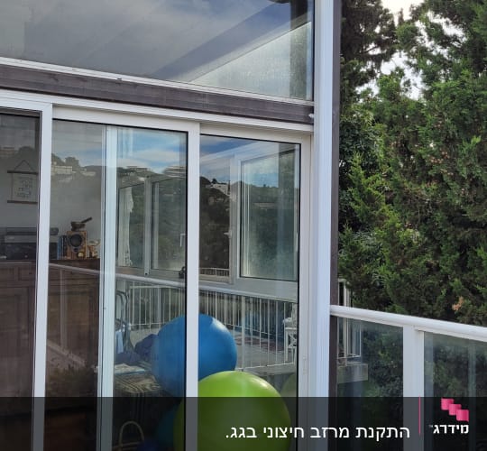 גג עם מרזב לבן ליד חלון זכוכית